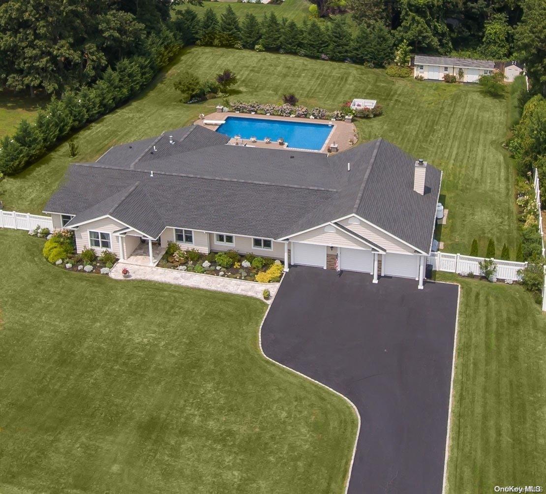 an aerial view of residential houses with outdoor space and a lake view