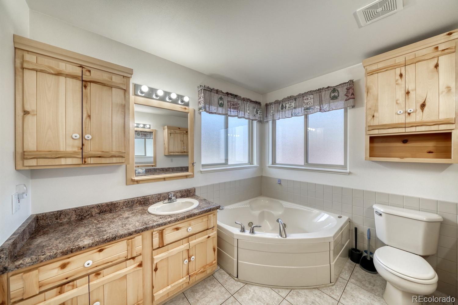 31015 West Ridge Road Buena Vista, CO 81211 - Photo 18 of 48 a bathroom with a granite countertop sink mirror vanity bathtub and toilet