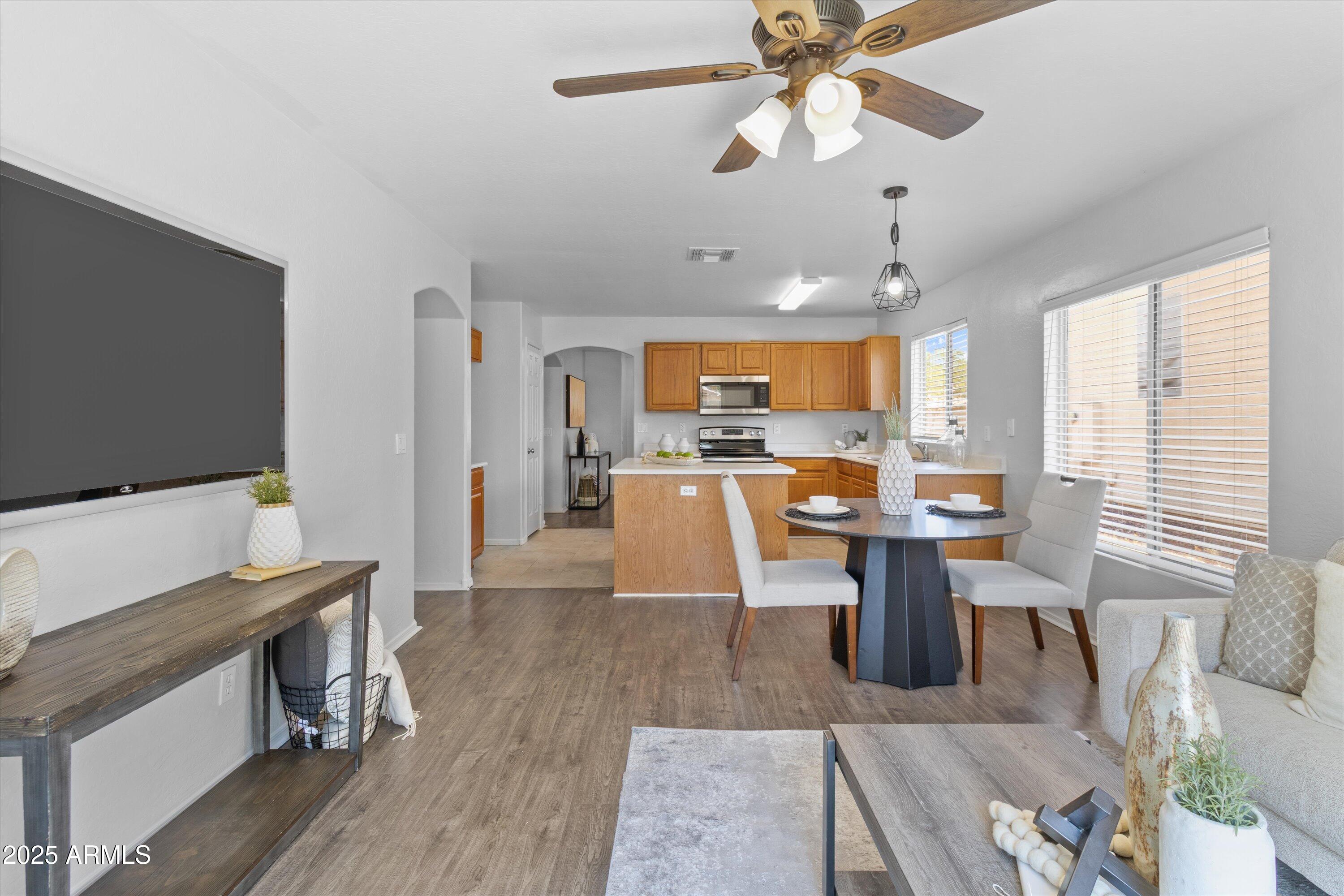 11921 West Bloomfield Road El Mirage, AZ 85335 - Photo 12 of 24 a living room with a dining table a flat screen tv and a large window