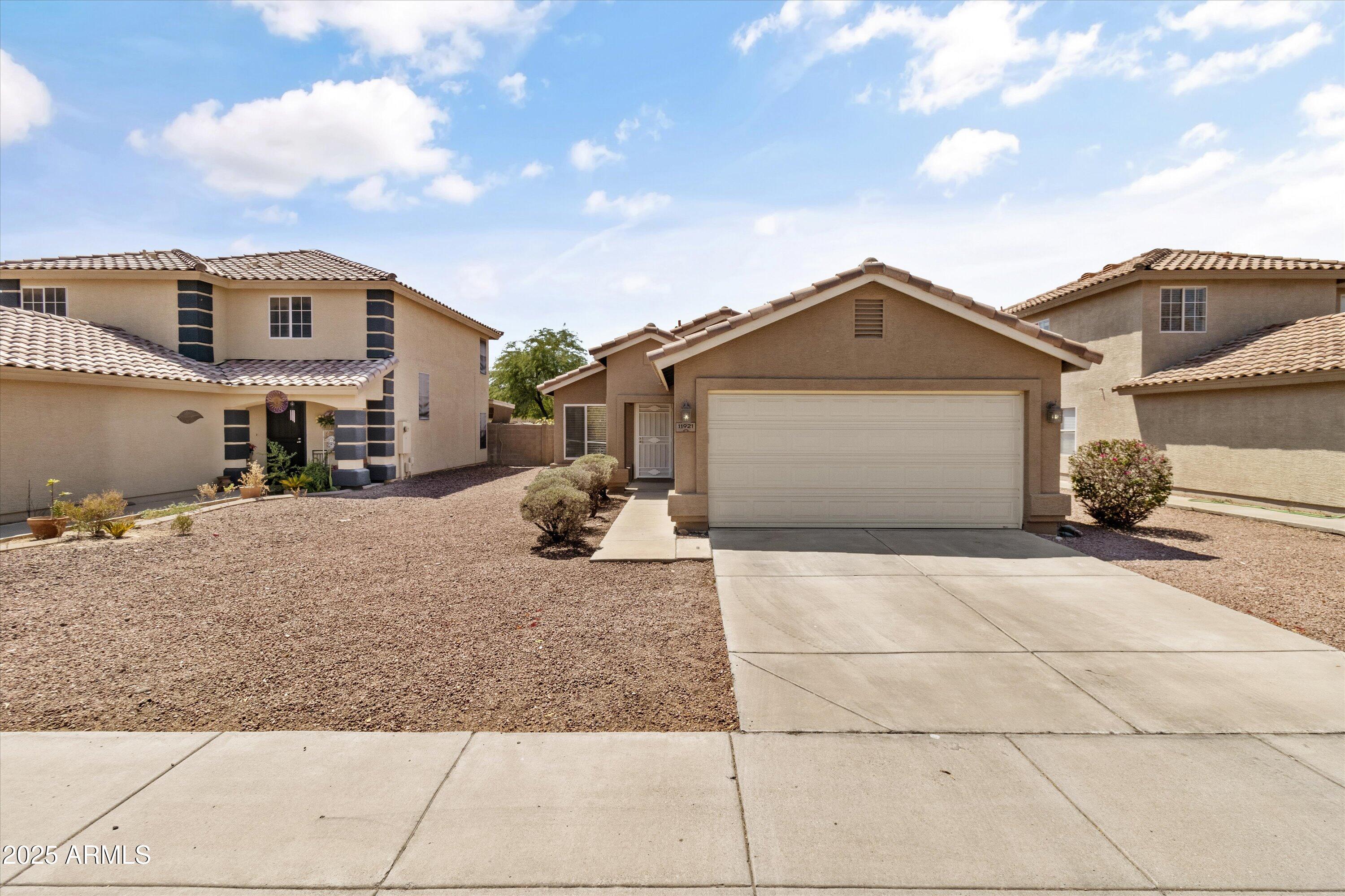 11921 West Bloomfield Road El Mirage, AZ 85335 - Photo 2 of 24 a front view of a house with a yard and garage