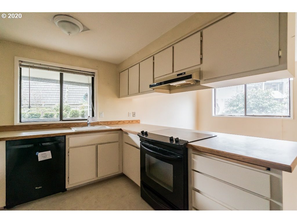 5620 Southwest Riverside Lane Portland, OR 97239 - Photo 22 of 25 a kitchen with stainless steel appliances granite countertop a sink a stove and a microwave