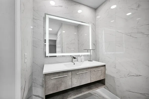 a view of swimming pool that has lawn chairs potted plants and palm tree