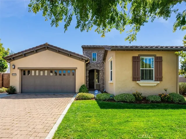 a front view of a house with a garden and garage