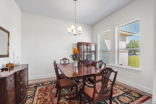 a view of a dining room with furniture a chandelier and wooden floor
