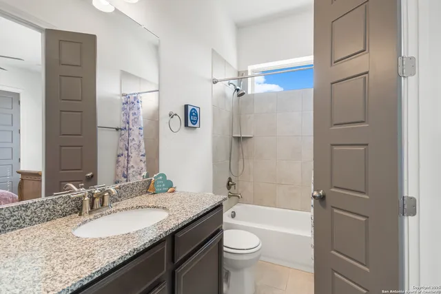 a bathroom with a granite countertop sink toilet and shower