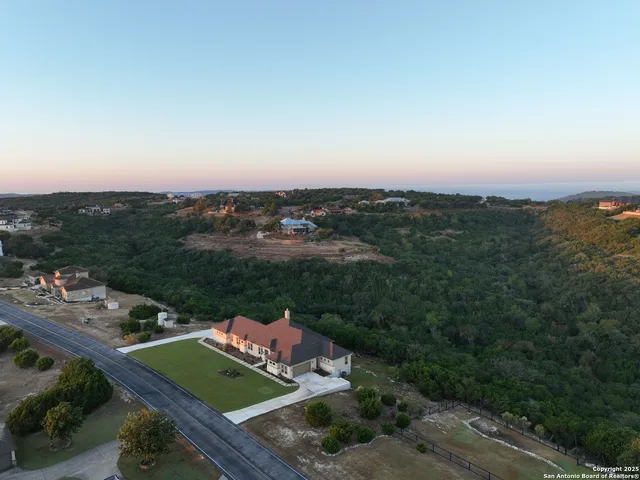 an aerial view of residential houses with outdoor space and trees