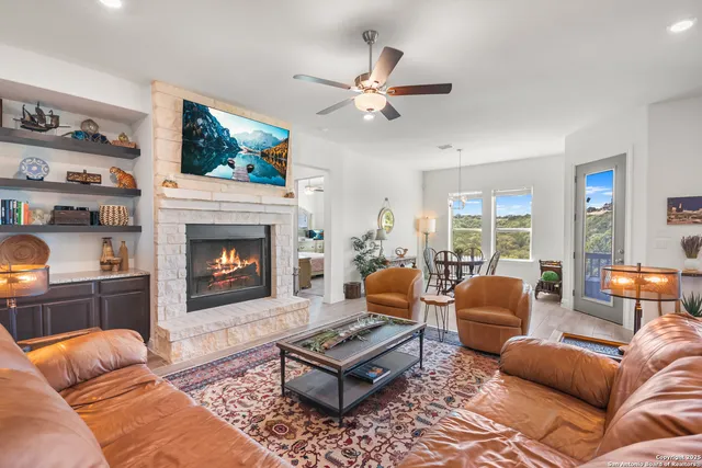 a living room with furniture a flat screen tv and a fireplace