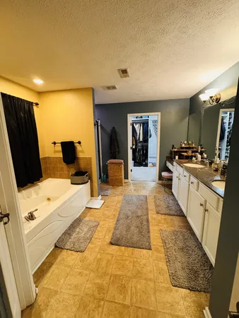 a spacious bedroom with a bed and wooden floor