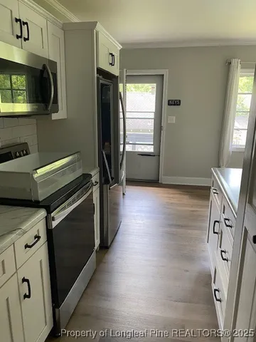 a kitchen with stainless steel appliances a stove microwave and refrigerator