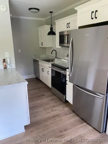 a kitchen with stainless steel appliances granite countertop a refrigerator a sink and a stove