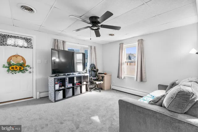 a living room with furniture and a ceiling fan