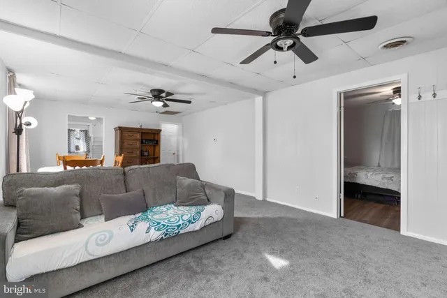 a living room with furniture and a ceiling fan