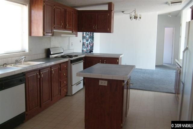 3840 Hummingbird Drive Reno, NV 89508 - Photo 3 of 9 a kitchen with stainless steel appliances granite countertop a sink stove and refrigerator