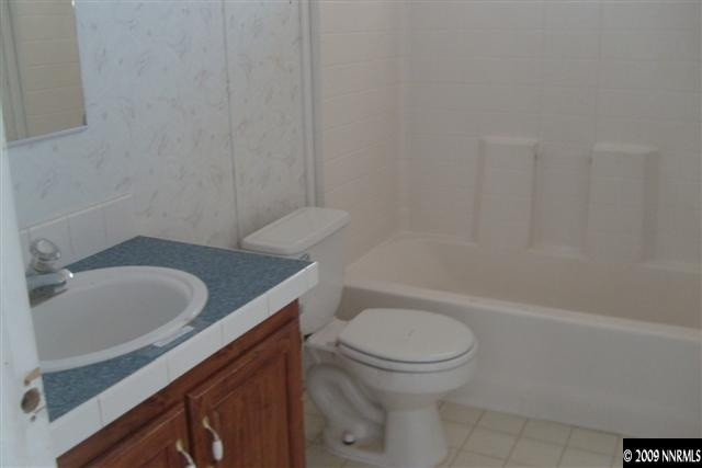 3840 Hummingbird Drive Reno, NV 89508 - Photo 7 of 9 a bathroom with a granite countertop toilet a sink and bathtub