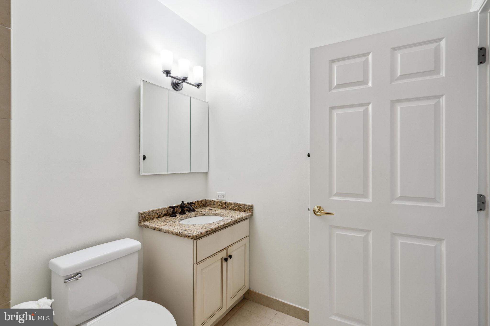1600 Arch Street, Unit 1113 Philadelphia, PA 19103 - Photo 17 of 34 a bathroom with a granite countertop sink and a toilet