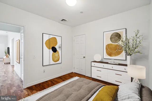 a bedroom with a bed and painting on the wall