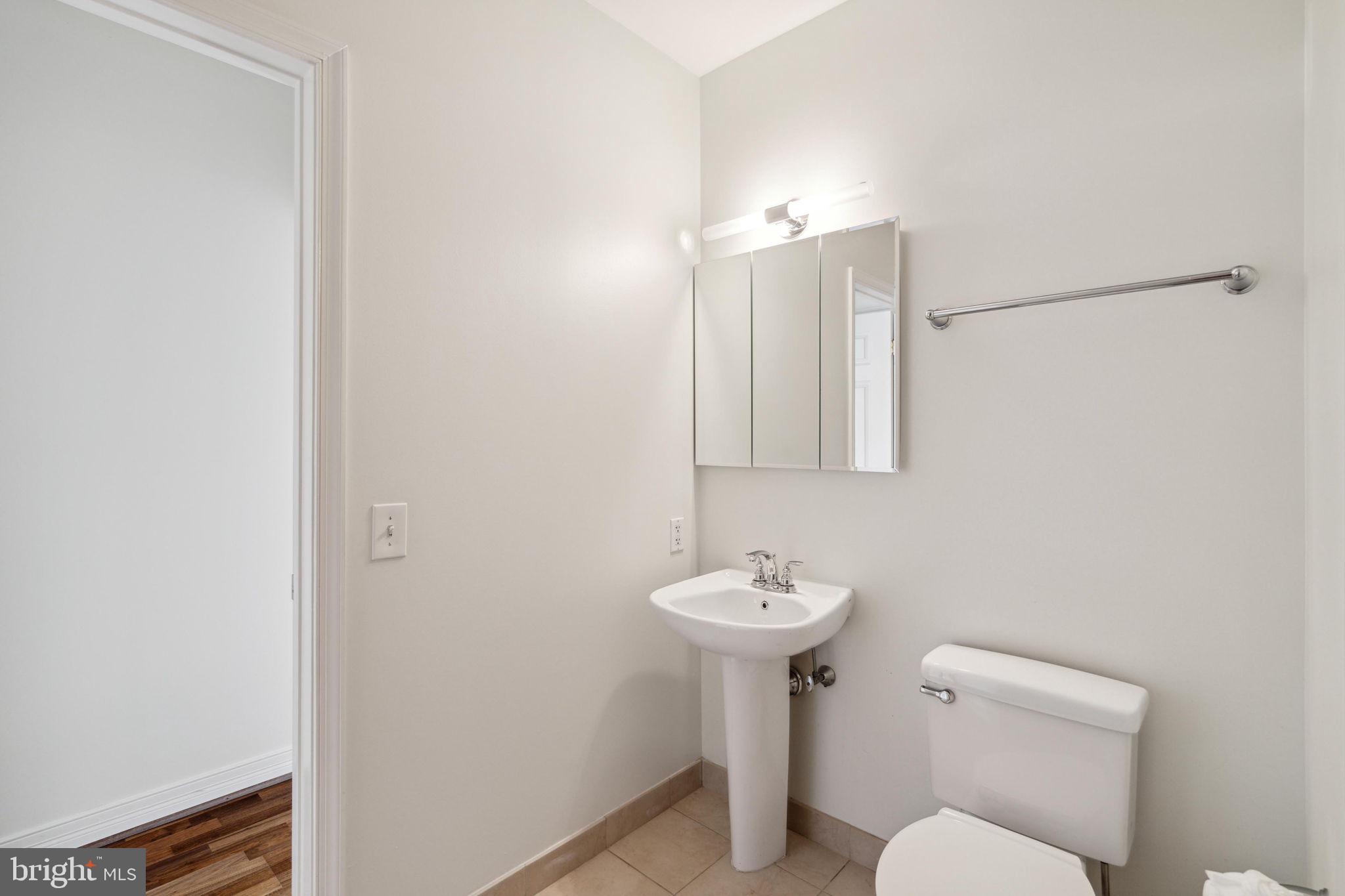 1600 Arch Street, Unit 1113 Philadelphia, PA 19103 - Photo 21 of 34 a bathroom with a sink toilet and mirror