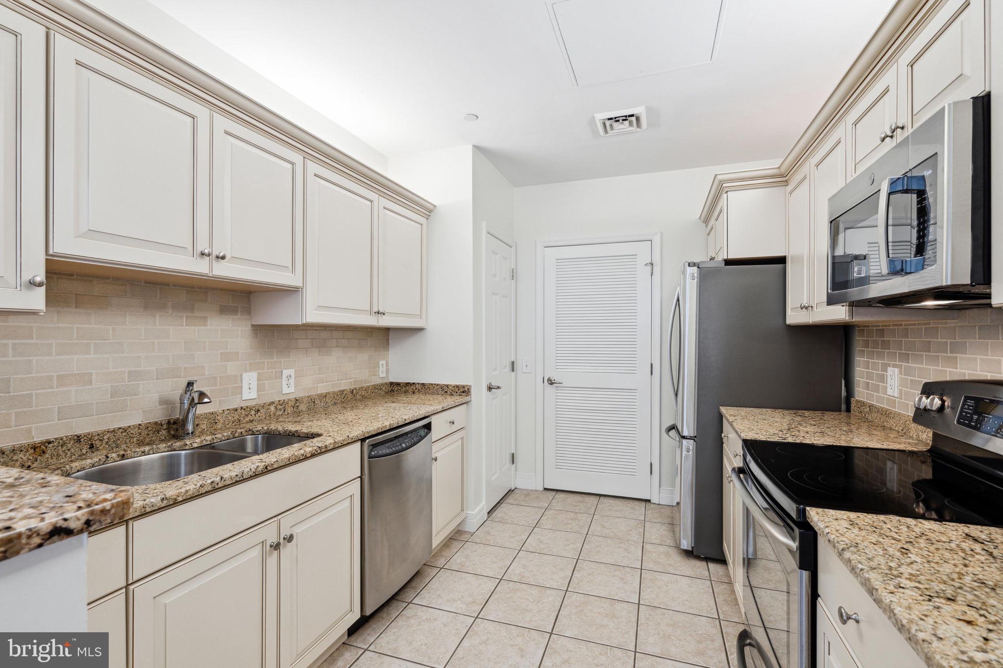 1600 Arch Street, Unit 1113 Philadelphia, PA 19103 - Photo 9 of 34 a kitchen with stainless steel appliances granite countertop a sink stove and cabinets