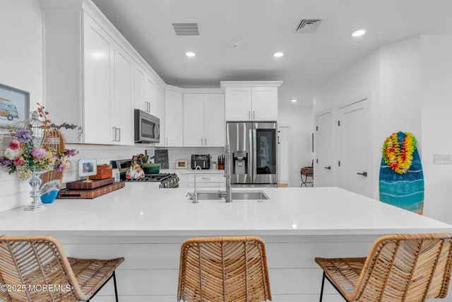 a kitchen with stainless steel appliances granite countertop a sink and a refrigerator