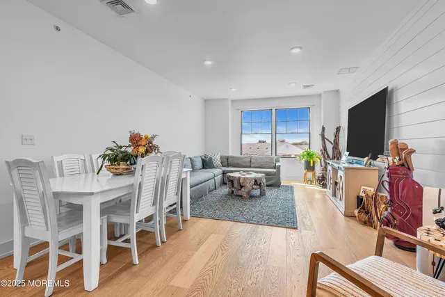 a living room with furniture a flat screen tv and a dining table