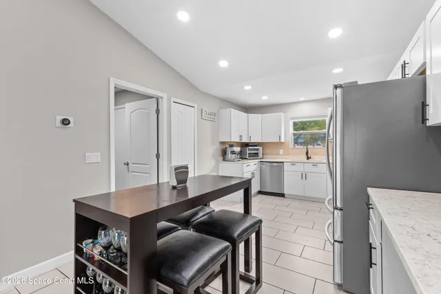 a kitchen with white cabinets and stainless steel appliances