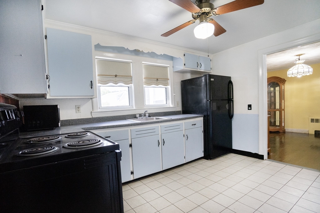 5 Hampton Street Saugus, MA 01906 - Photo 16 of 24 a kitchen with stainless steel appliances granite countertop a refrigerator a stove a sink and a microwave
