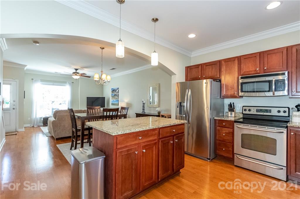 4128 Walker Road Charlotte, NC 28211 - Photo 15 of 31 a kitchen with a refrigerator a stove top oven a sink dishwasher and dining table with wooden floor