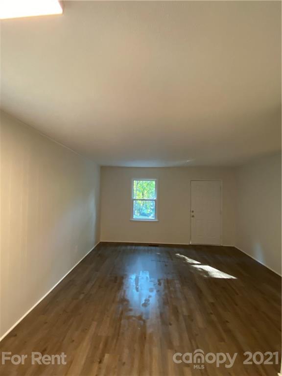 562 Rhyne Street North, Unit B Gastonia, NC 28054 - Photo 2 of 9 an empty room with wooden floor and windows