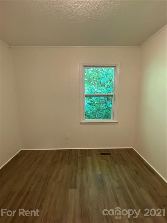 562 Rhyne Street North, Unit B Gastonia, NC 28054 - Photo 9 of 9 an empty room with wooden floor and windows