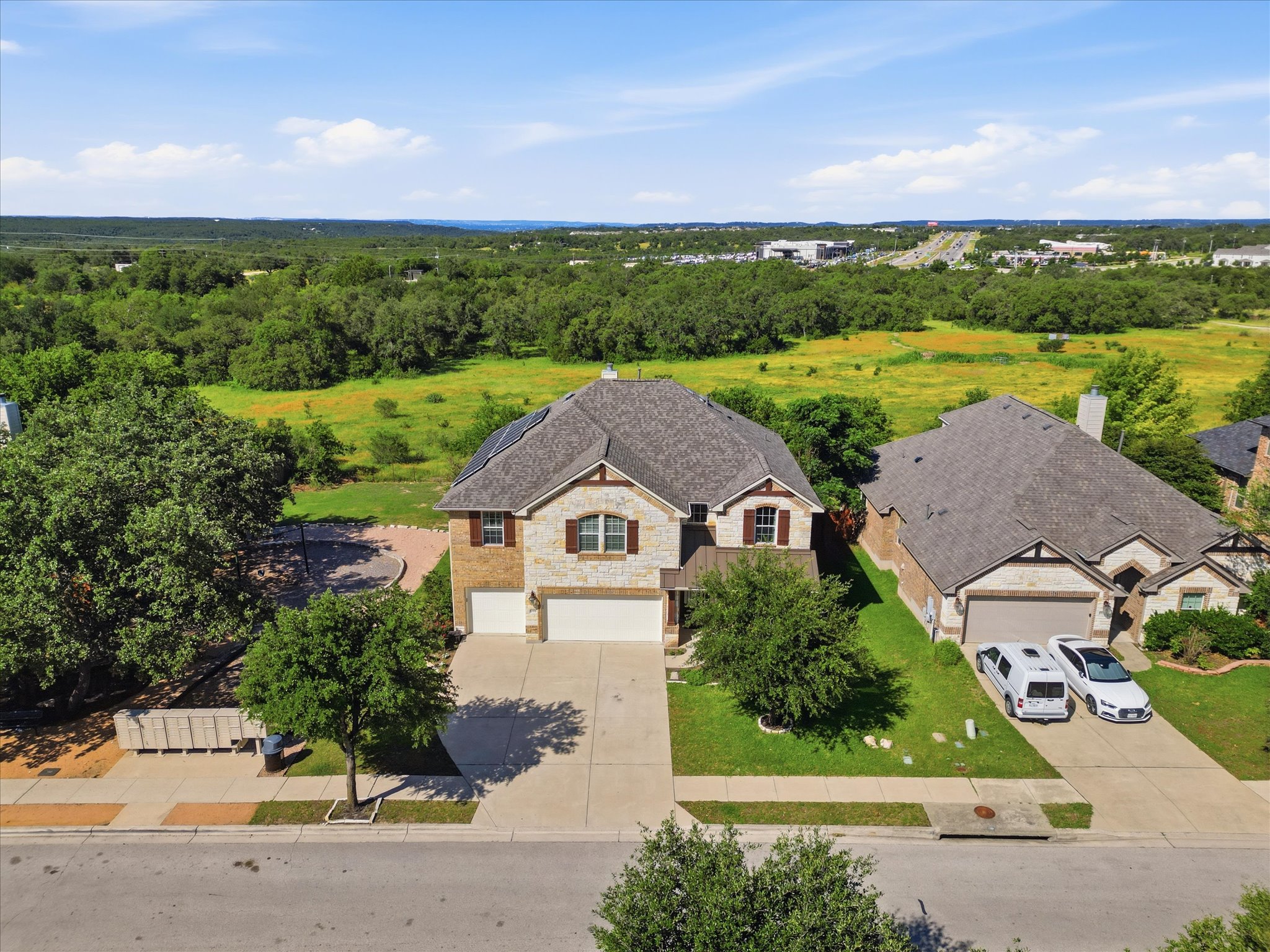 1511 Rimstone Drive Cedar Park, TX 78613 - Photo 1 of 39 Great energy from left side of lovely children playground with big open hill country green belt view rick facade home with attached garages and verdant surroundings.