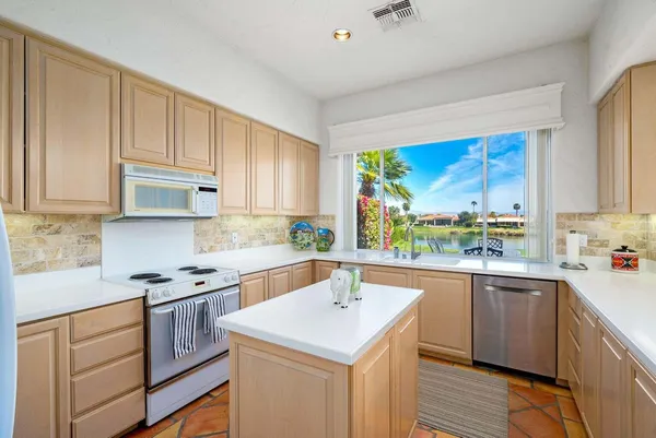a kitchen with granite countertop a sink stove and cabinets