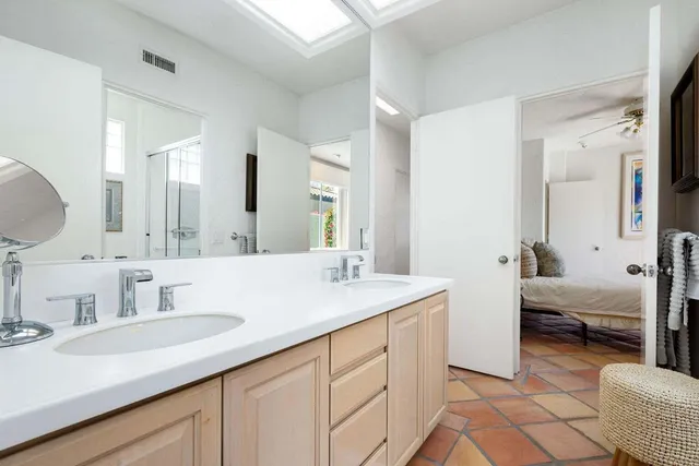 a en suite bathroom with double sink and a large mirror