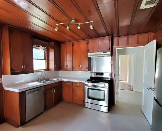 a kitchen with stainless steel appliances granite countertop a stove a sink and a refrigerator