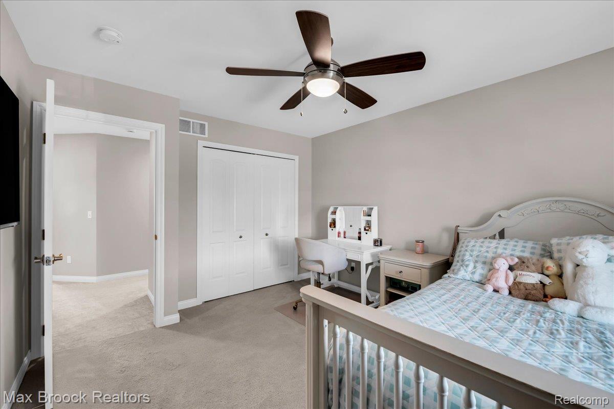 1126 Queensboro Drive Rochester, MI 48307 - Photo 33 of 66 Bedroom featuring light gray wall paint, a ceiling fan with integrated lighting, carpeted flooring, white bi-fold closet doors, and white trim throughout