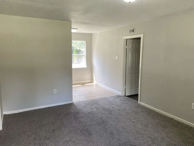 an empty room with windows and closet