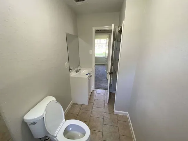 a white toilet sitting next to a shower