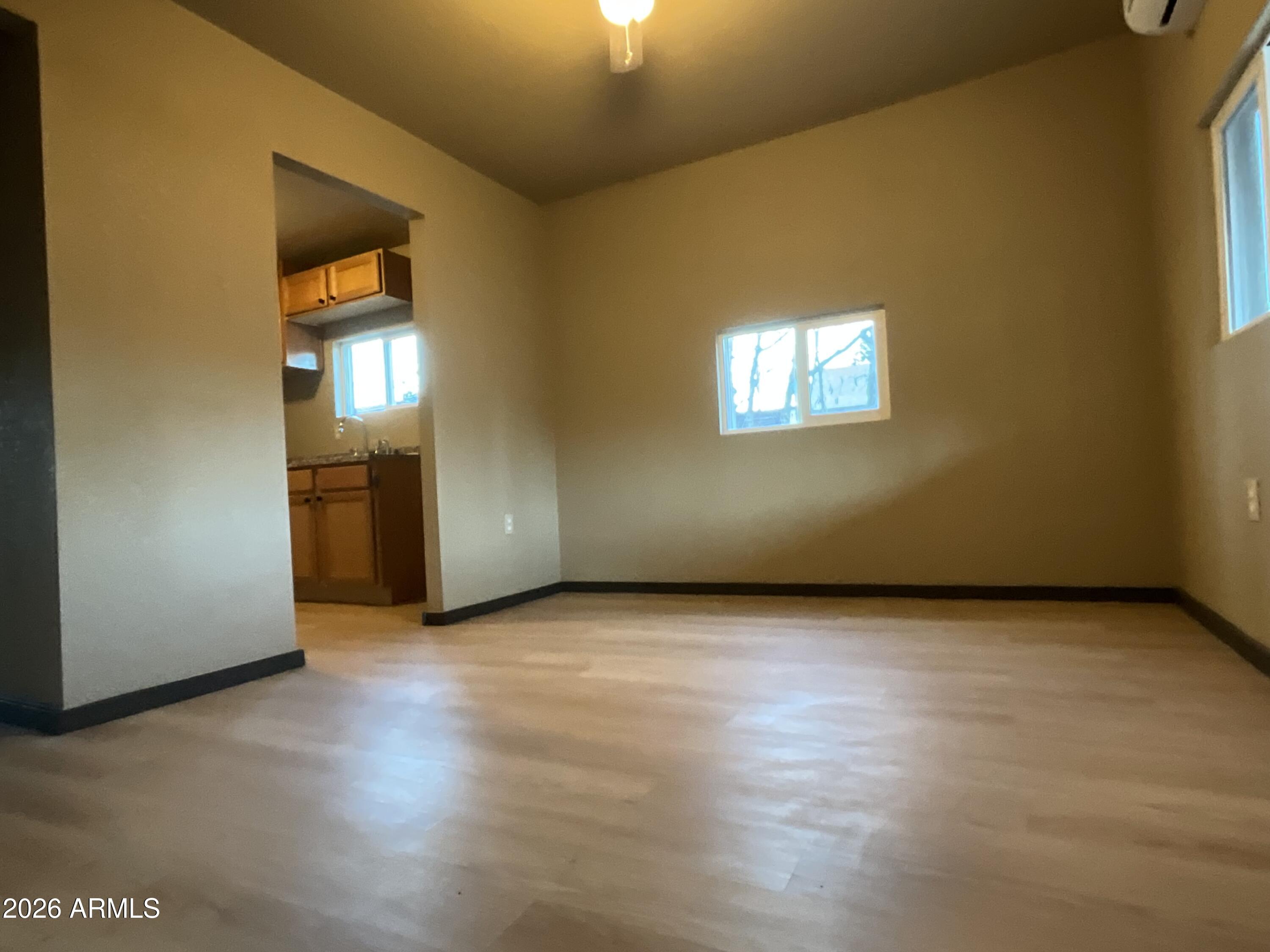 4382 East Copper Street Claypool, AZ 85532 - Photo 2 of 10 an empty room with wooden floor and windows