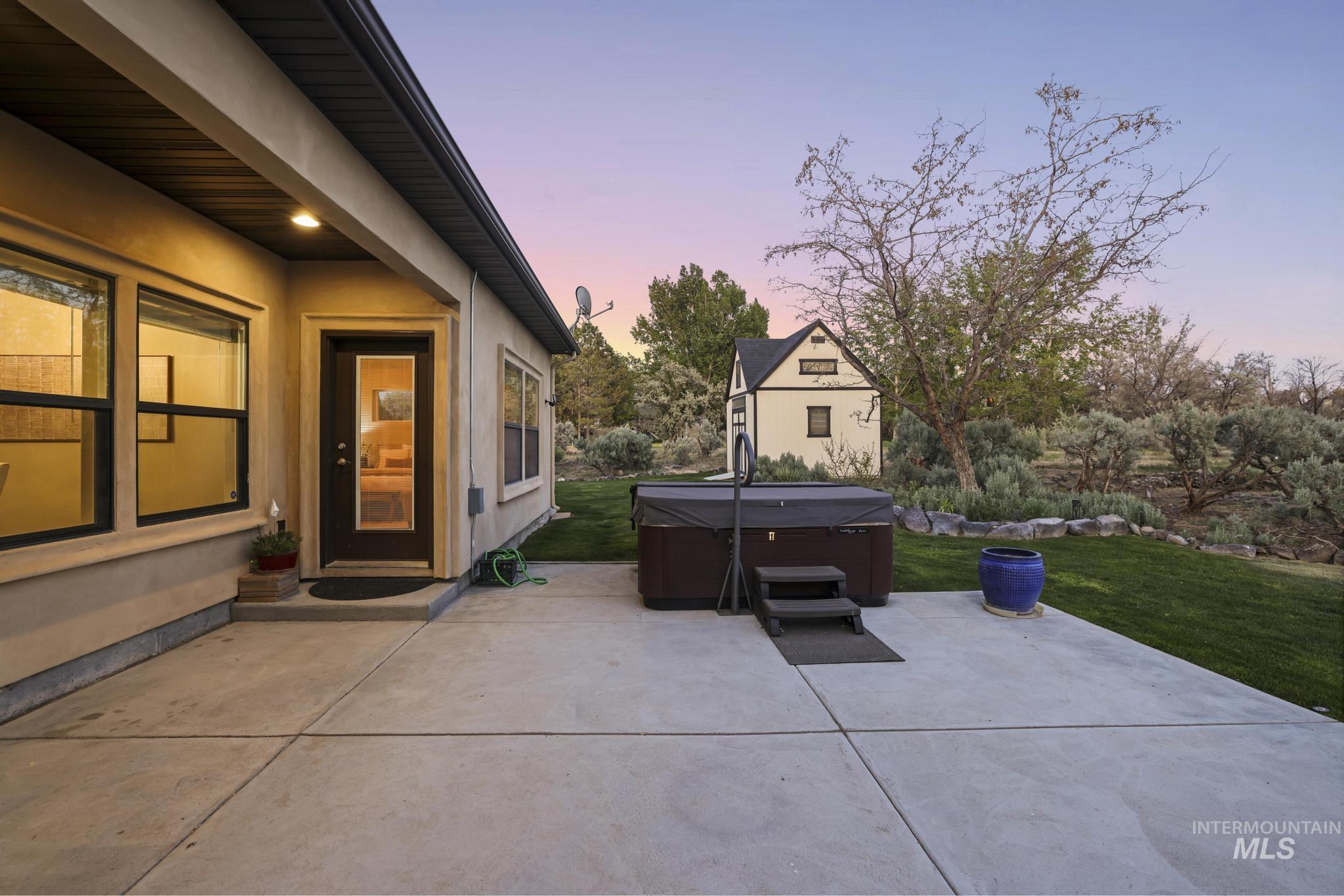 4152 North Meadow Ridge Circle Twin Falls, ID 83301 - Photo 44 of 50 Expansive concrete patio with spa, backing to a landscaped yard featuring a small outbuilding