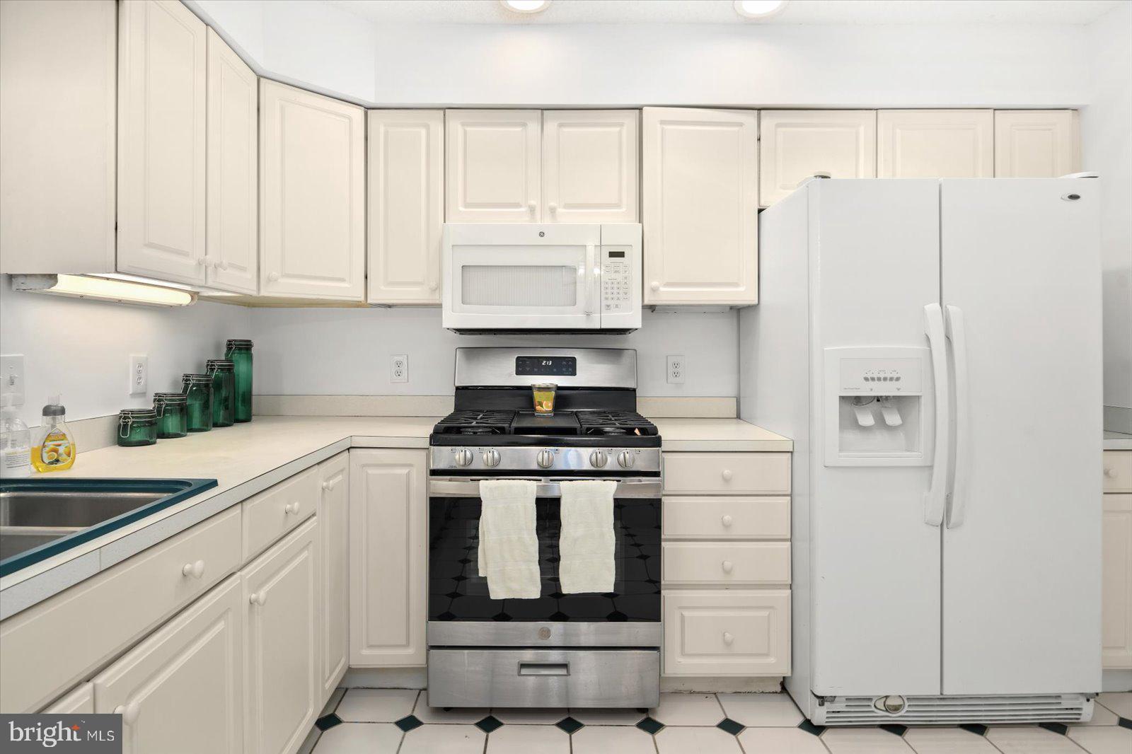 68 Falcon Bridge Road Berlin, MD 21811 - Photo 14 of 71 a kitchen with stainless steel appliances granite countertop a refrigerator stove and white cabinets