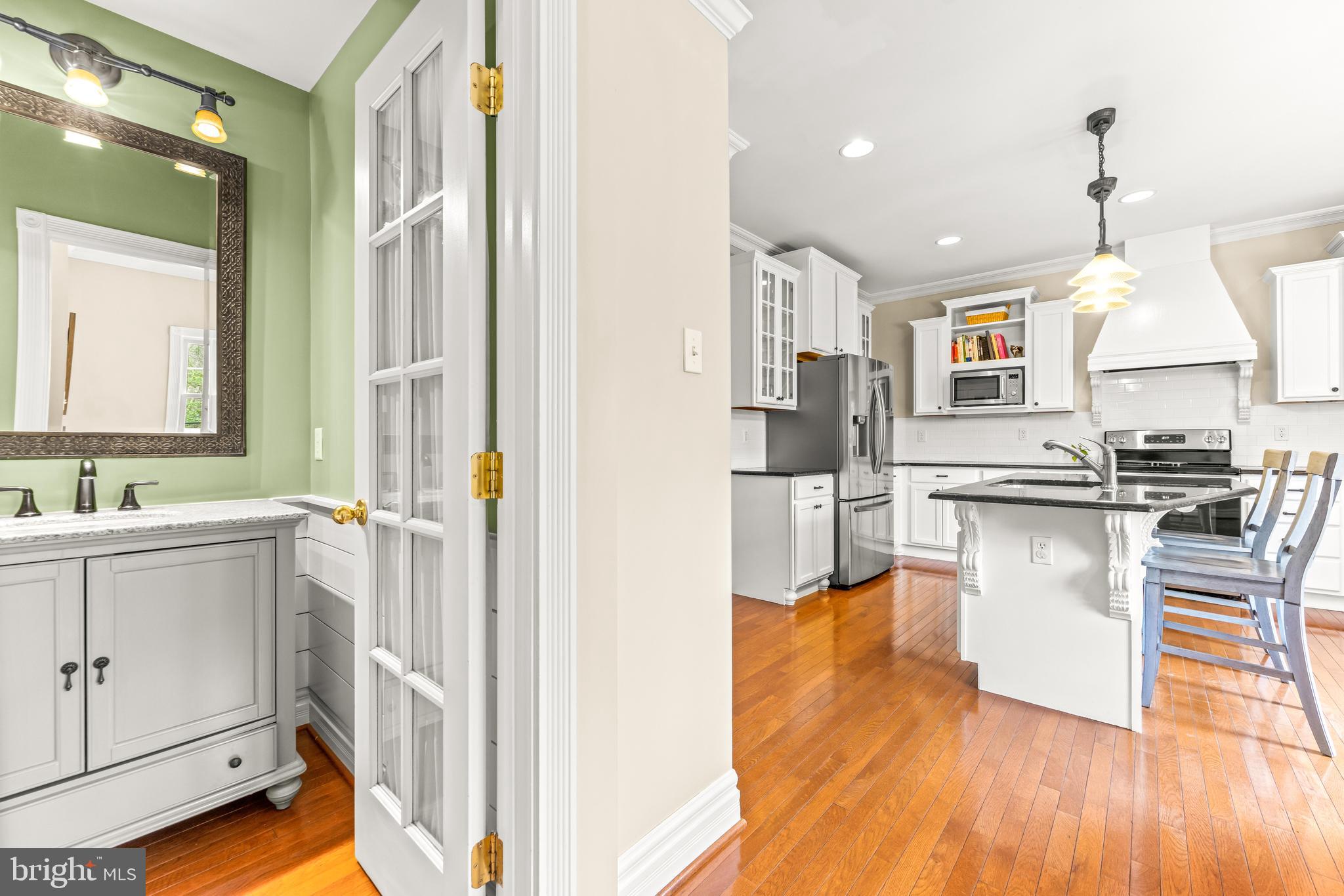 776 Snodgrass Road Crownsville, MD 21032 - Photo 24 of 82 a kitchen with stainless steel appliances granite countertop a refrigerator a sink dishwasher and white cabinets with wooden floor