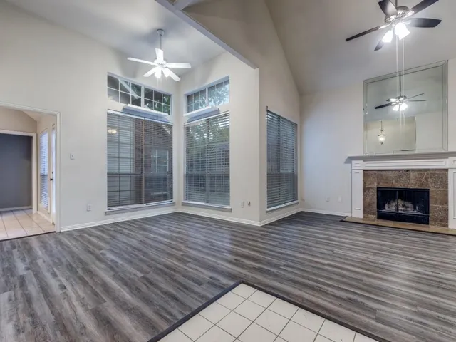 a view of a livingroom with a fireplace window and wooden floor