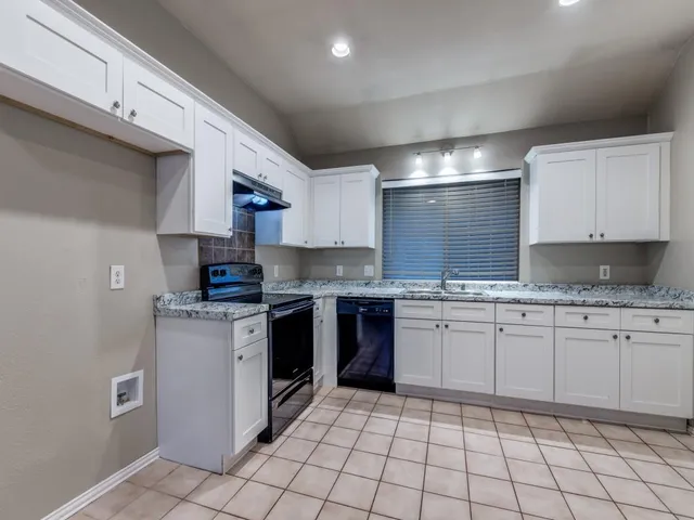 a kitchen with stainless steel appliances granite countertop a sink and cabinets