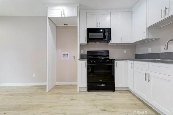 a kitchen with white cabinets and stainless steel appliances