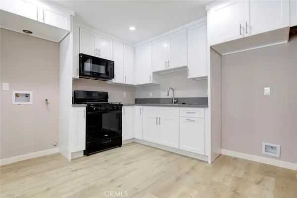 a bathroom with a toilet sink vanity and a shower