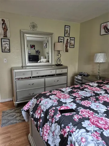 a bedroom with a bed and a lamp on dresser