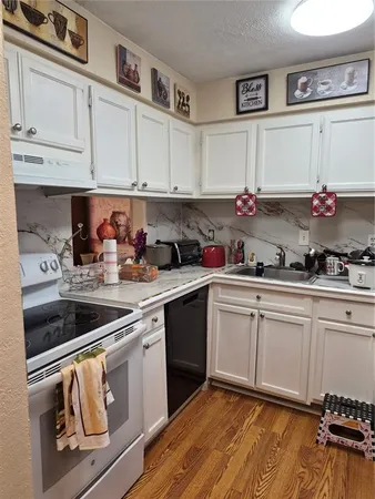 a kitchen with granite countertop white cabinets and white appliances