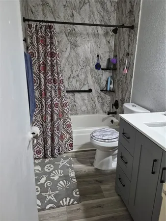 a bathroom with a toilet and a shower curtain