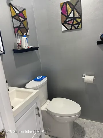 a white toilet sitting next to a white walls and vanity