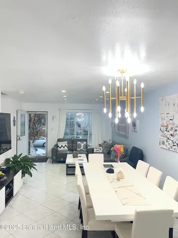 a living room with furniture a chandelier and a dining table