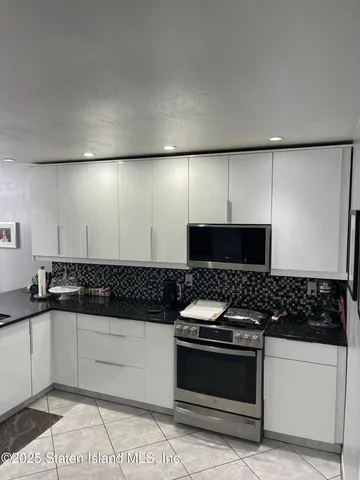 a kitchen with granite countertop a stove and a refrigerator